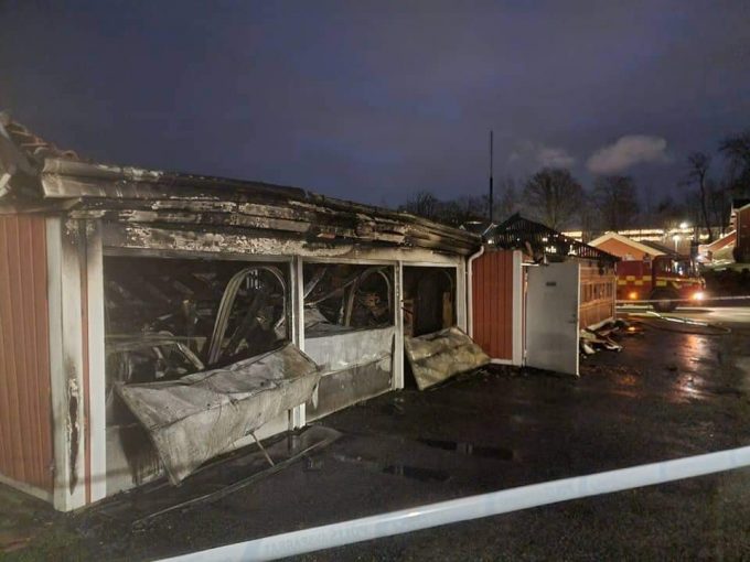 Bilden visar ett garage med utbrända bilar.