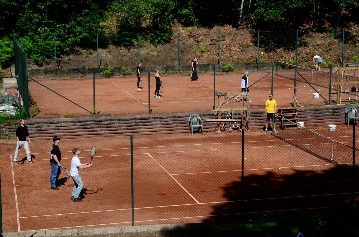 Bilden visar ungdomar på tennisbanan.